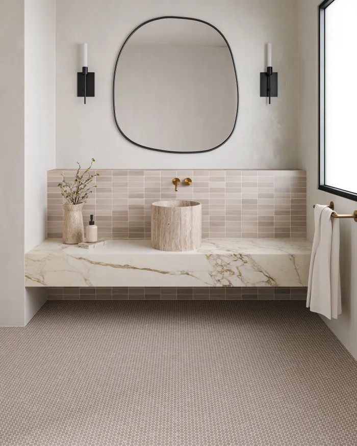 Travertine vessel sink on a calacatta marble floating vanity with stacked tile backsplash