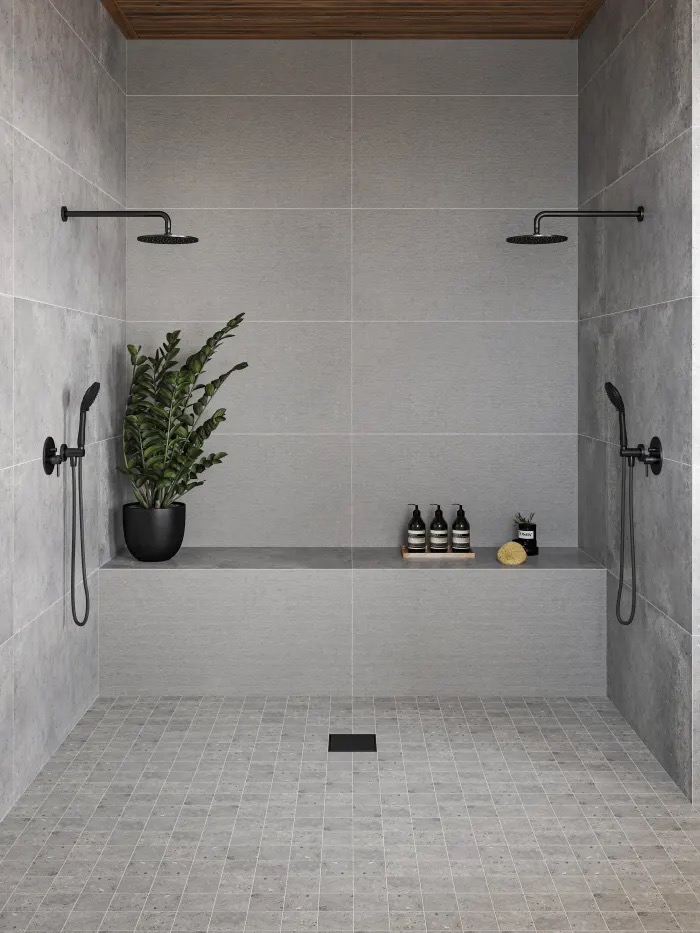 Grey large-format porcelain wet room with dual rain showers and bench