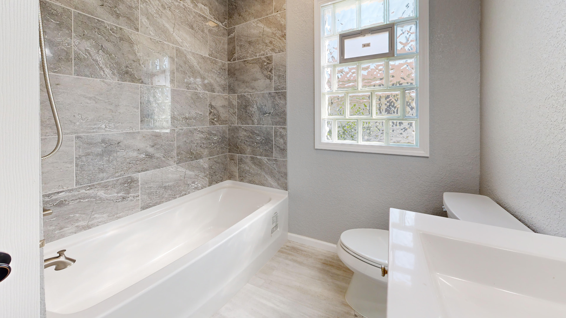 Marble-look porcelain tile tub and shower surround with wood-look flooring, Upland California